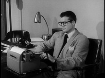 Clark Kent typing on his typewriter