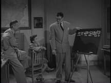 Clark shows Lois and the Inspector a chalkboard with pictures and names of the items from the statues