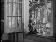 Pepi sits on the window sill, note still in his mouth