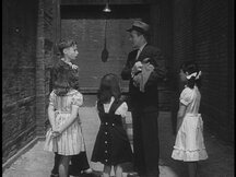 Max holding Pepi the monkey in an alley, surrounded by kids